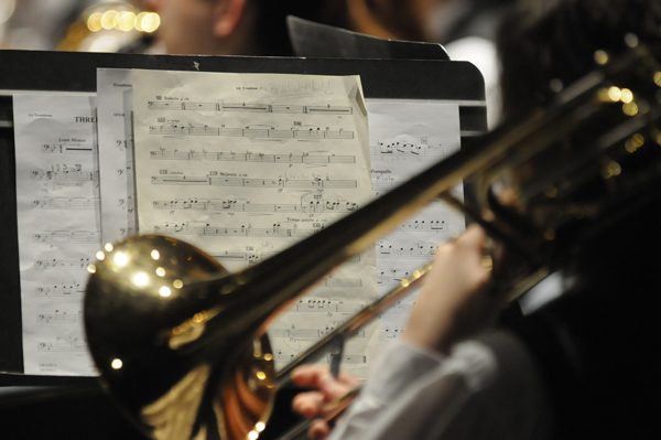 A trombone bell in front of sheet music